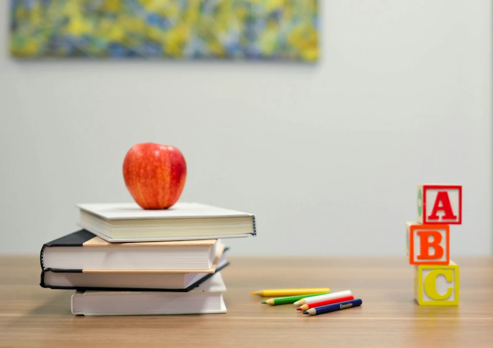 Books, pencils and alphabet blocks on a classroom table